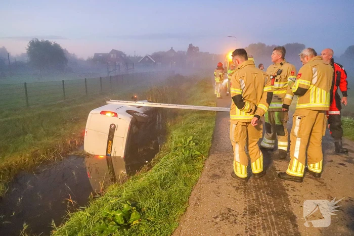 Bestelbus belandt op zijn kant in sloot