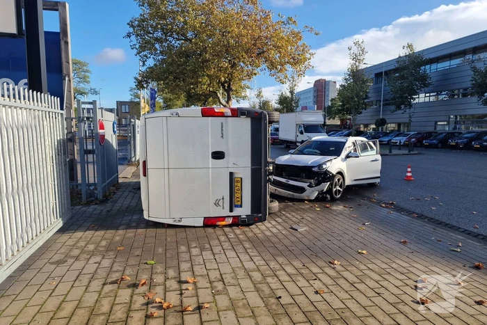 Bestelbus belandt op zijn kant bij botsing met auto