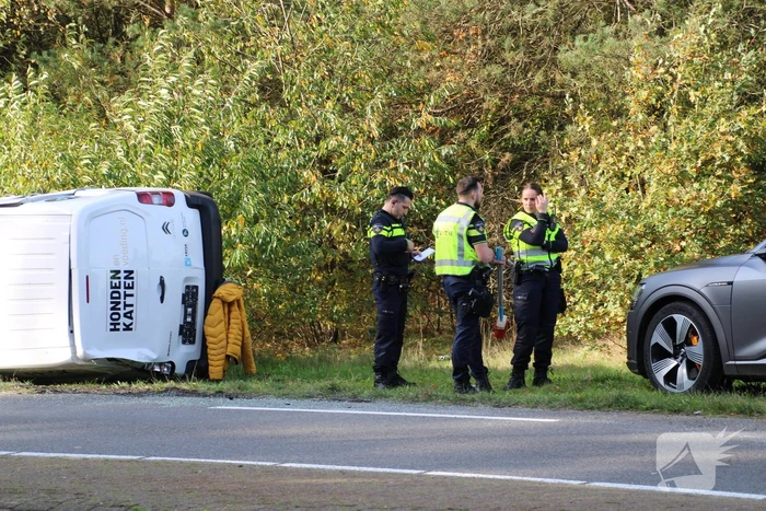 Bestelbus op zijn kant na ongeval