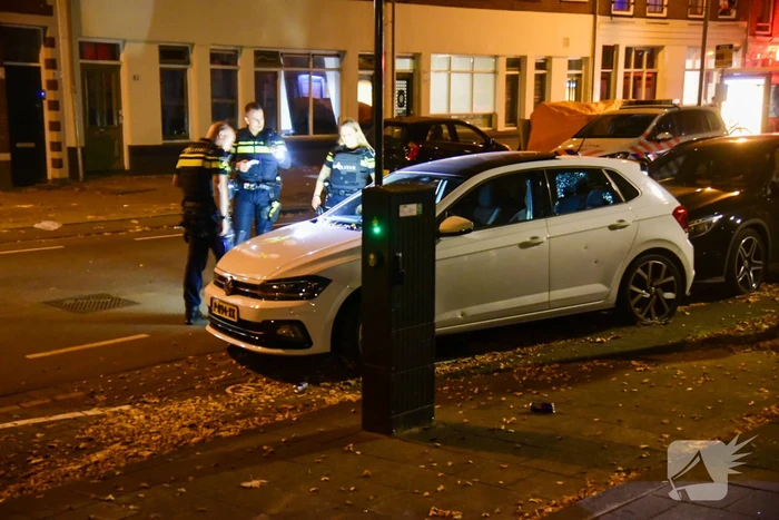 Persoon lost schoten op auto