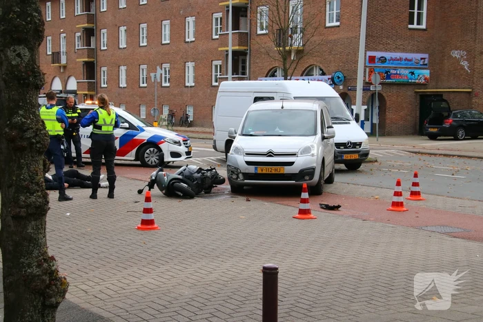 Afslaande bestelbus ziet scooterrijder over het hoofd
