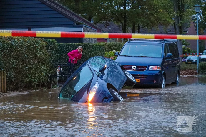 Auto zakt in sinkhole door gesprongen hoofdwaterleiding