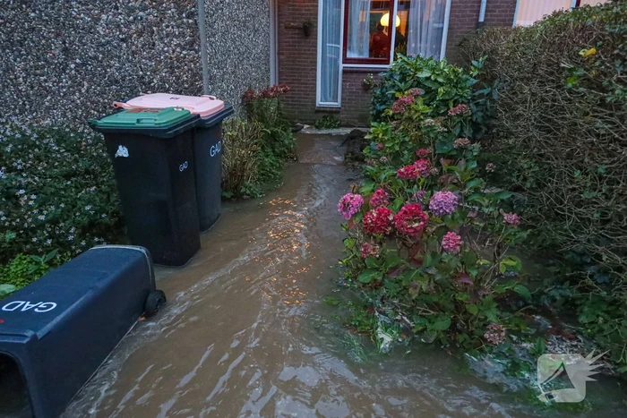 Auto zakt in sinkhole door gesprongen hoofdwaterleiding