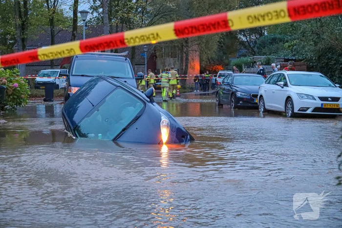 Auto zakt in sinkhole door gesprongen hoofdwaterleiding