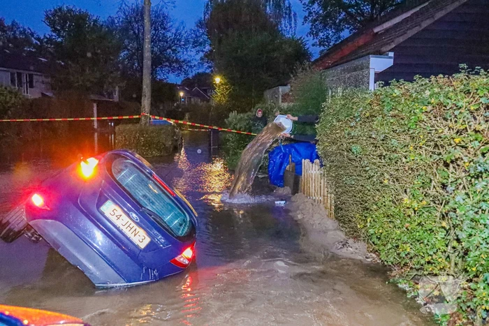Auto zakt in sinkhole door gesprongen hoofdwaterleiding