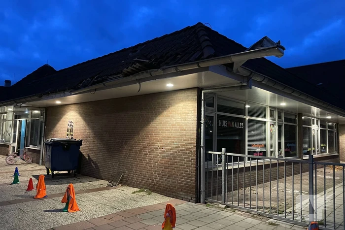 Vrachtwagen rijdt tegen dak van gebouw