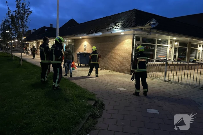 Vrachtwagen rijdt tegen dak van gebouw