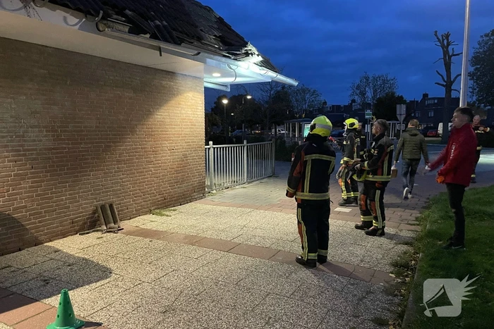 Vrachtwagen rijdt tegen dak van gebouw