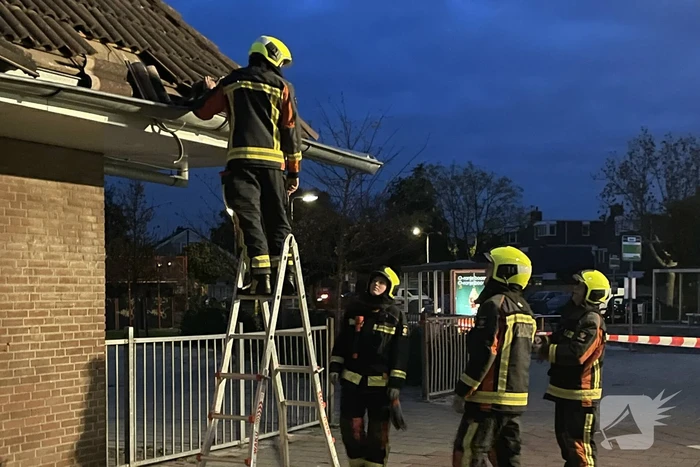 Vrachtwagen rijdt tegen dak van gebouw