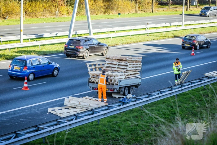 Automobilist verliest overbeladen aanhangwagen met pallets en crasht