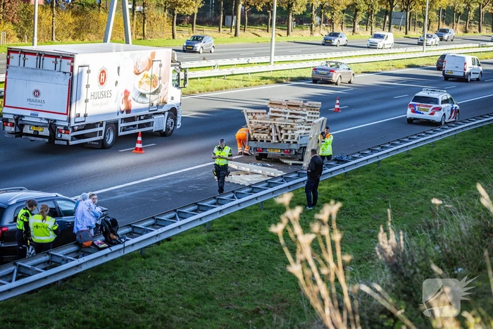 Automobilist verliest overbeladen aanhangwagen met pallets en crasht