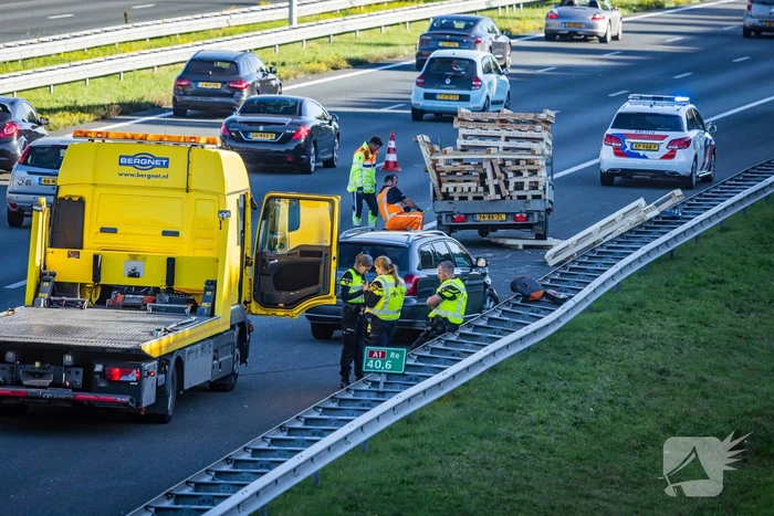 Automobilist verliest overbeladen aanhangwagen met pallets en crasht