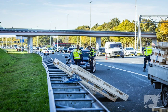 Automobilist verliest overbeladen aanhangwagen met pallets en crasht