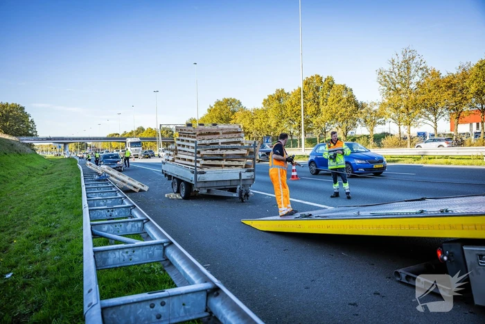 Automobilist verliest overbeladen aanhangwagen met pallets en crasht