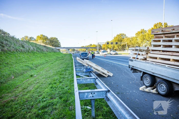 Automobilist verliest overbeladen aanhangwagen met pallets en crasht