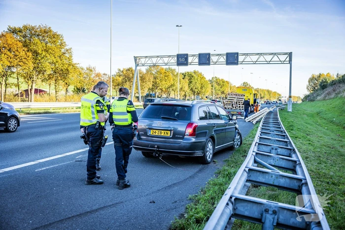 Automobilist verliest overbeladen aanhangwagen met pallets en crasht