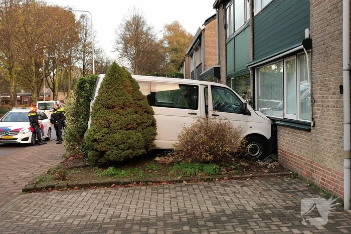 Taxibus met kinderen rijdt tegen woning