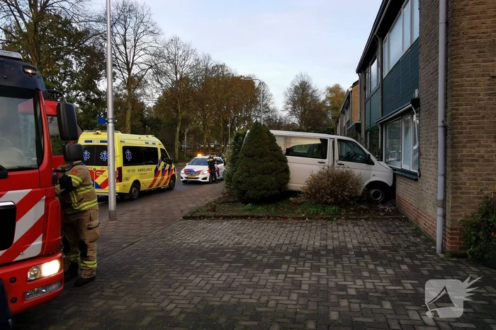 Taxibus met kinderen rijdt tegen woning