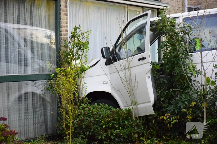 Taxibus met kinderen rijdt tegen woning