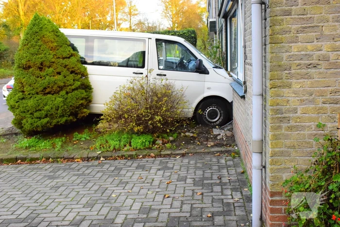 Taxibus met kinderen rijdt tegen woning