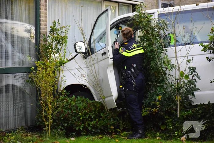 Taxibus met kinderen rijdt tegen woning