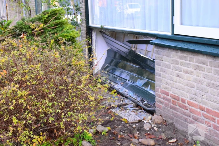 Taxibus met kinderen rijdt tegen woning