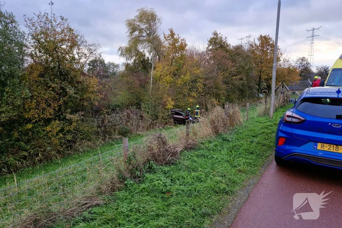 Auto rolt van de dijk af