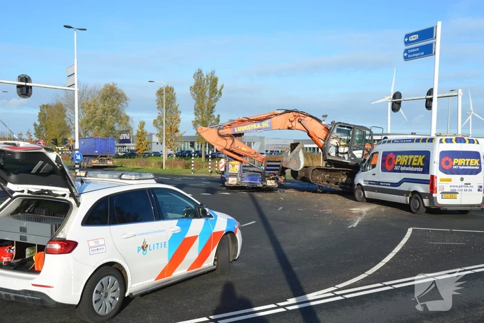 Graafmachine valt van dieplader