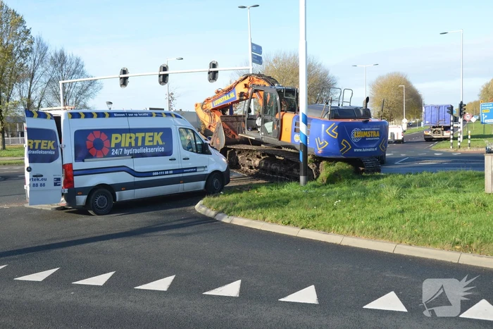 Graafmachine valt van dieplader