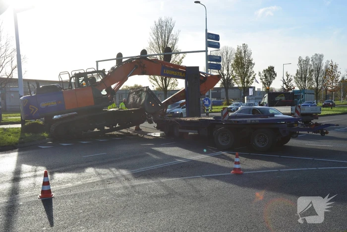 Graafmachine valt van dieplader