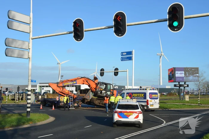 Graafmachine valt van dieplader