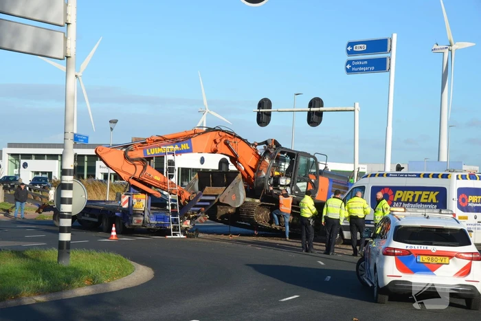 Graafmachine valt van dieplader