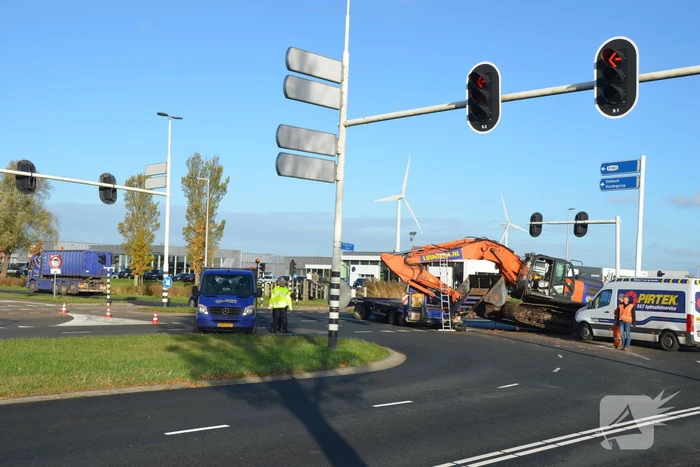 Graafmachine valt van dieplader