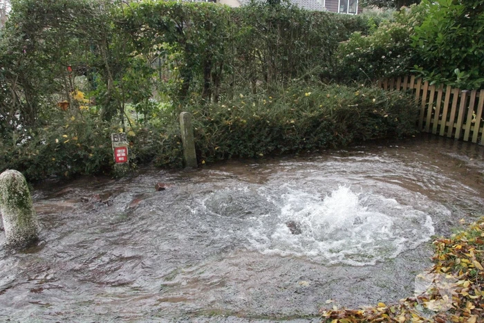 Straat onderwater door gesprongen waterleiding