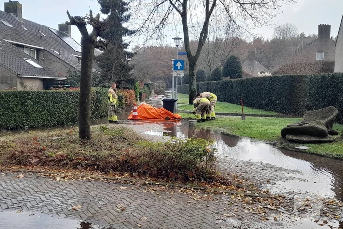 Straat onderwater door gesprongen waterleiding