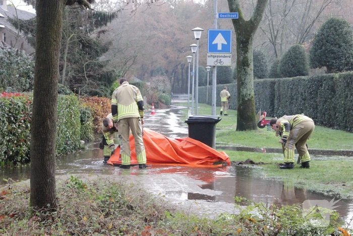 Straat onderwater door gesprongen waterleiding