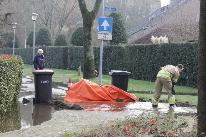 Straat onderwater door gesprongen waterleiding