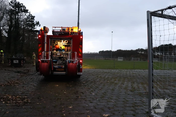 Wasmachine in brand tegen gebouw