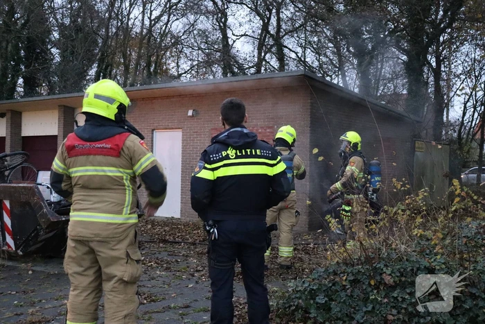 Wasmachine in brand tegen gebouw