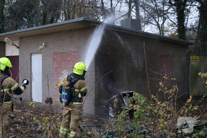 Wasmachine in brand tegen gebouw