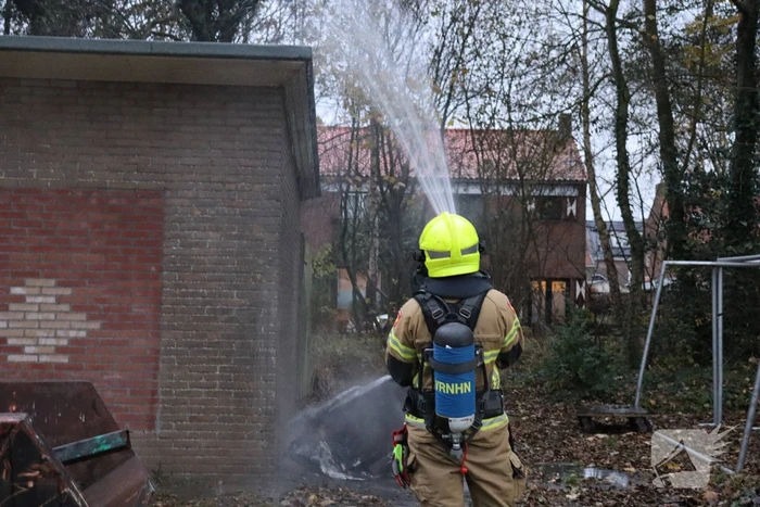 Wasmachine in brand tegen gebouw