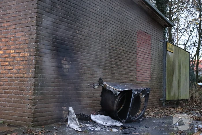 Wasmachine in brand tegen gebouw