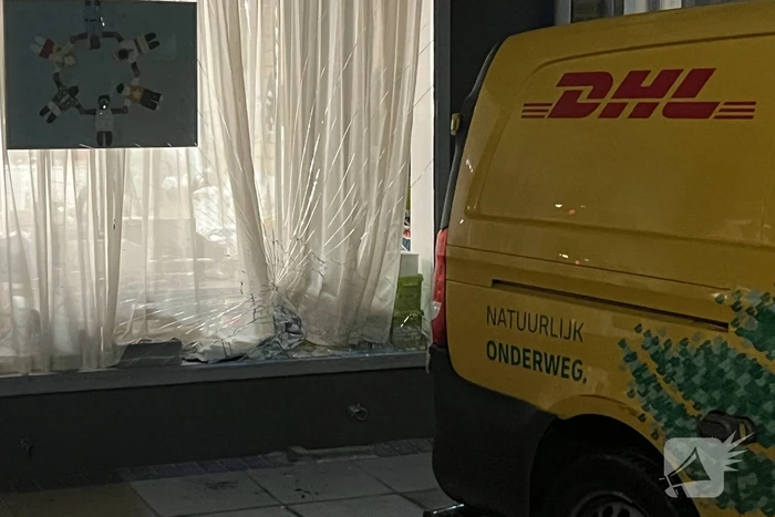 DHL bezorger ramt gevel na achteruit rijden