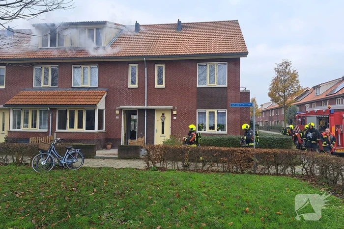 Veel rook uit dakkapel bij woningbrand