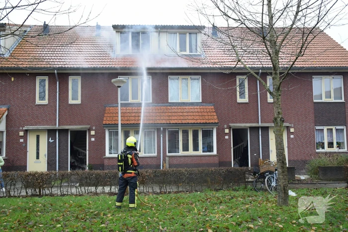 Veel rook uit dakkapel bij woningbrand