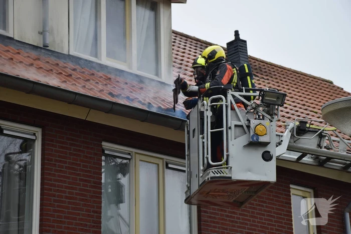 Veel rook uit dakkapel bij woningbrand