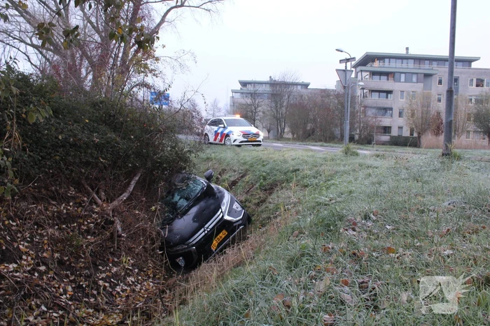 Auto raakt van de weg en belandt half in de sloot