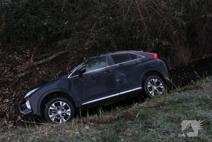Auto raakt van de weg en belandt half in de sloot