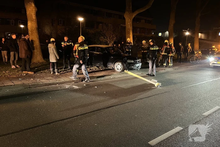Automobilist ramt lantaarnpaal en elektriciteitskast
