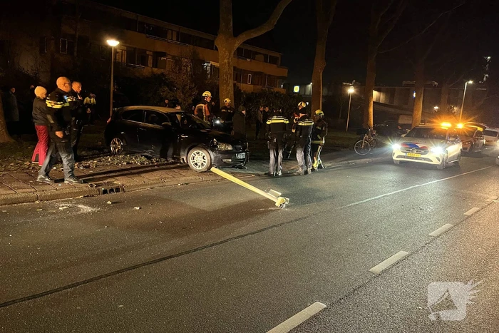 Automobilist ramt lantaarnpaal en elektriciteitskast